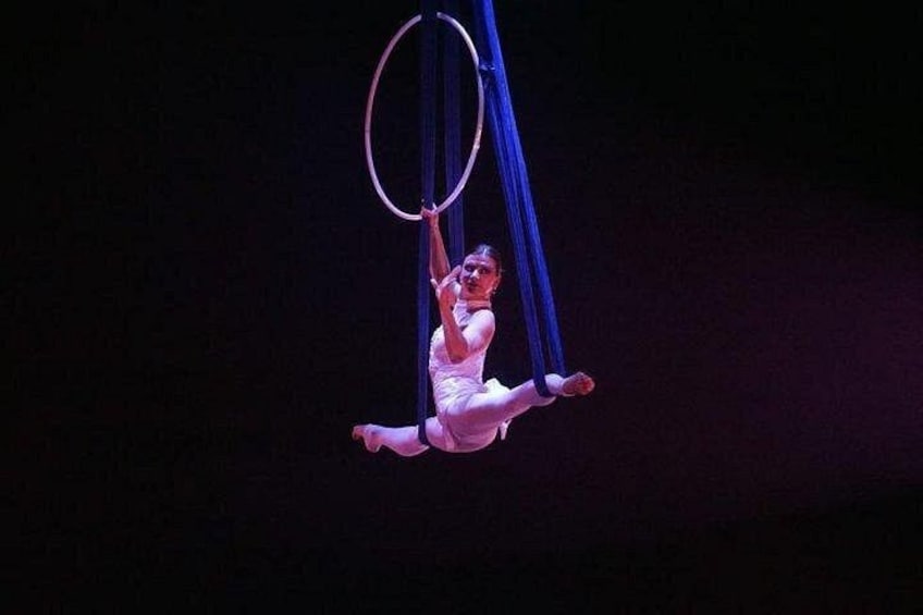 A person performing aerial acrobatics using blue aerial silks. 5