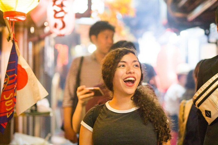 A person in a crowded market with traditional Japanese lanterns and signage. 2