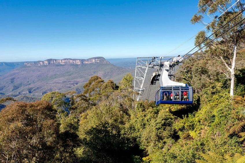 A cable car on a mountain with a clear view of the landscape. 2