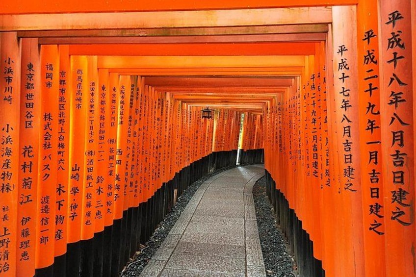 A corridor with orange pillars and black bases, lined with Japanese characters. 1