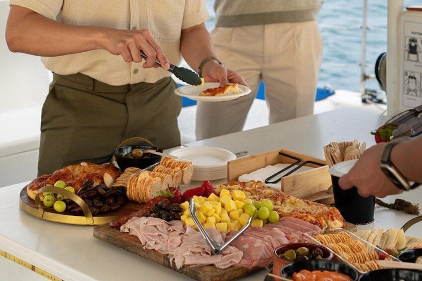 Een buffettafel met diverse soorten eten, zoals vlees, kaas en fruit. 3