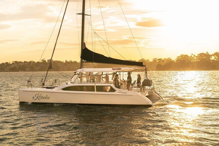 Een witte jacht, genaamd 'Kraklee', op rustig water tijdens de zonsondergang. 1
