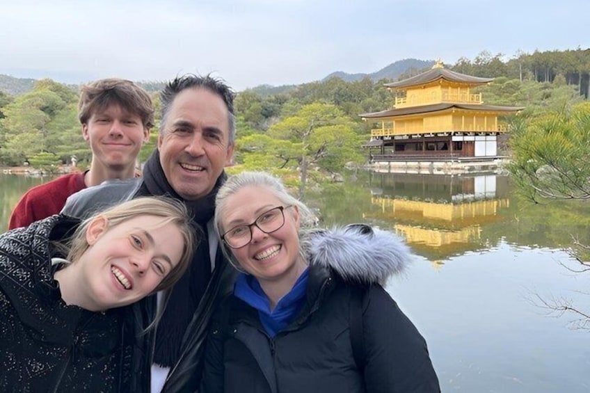 A group of people in front of a traditional building by a calm lake. 4