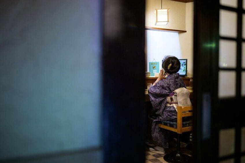 Eine Person sitzt an einem Schreibtisch mit einem Computer in einem Raum mit traditioneller japanischer Schiebetür. 5