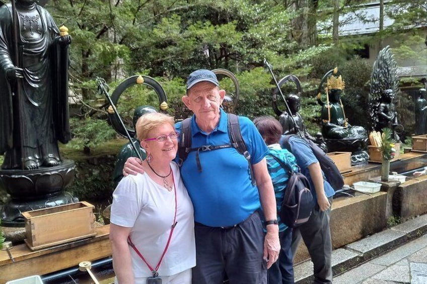 A couple standing in front of a statue with a child in the background. 2