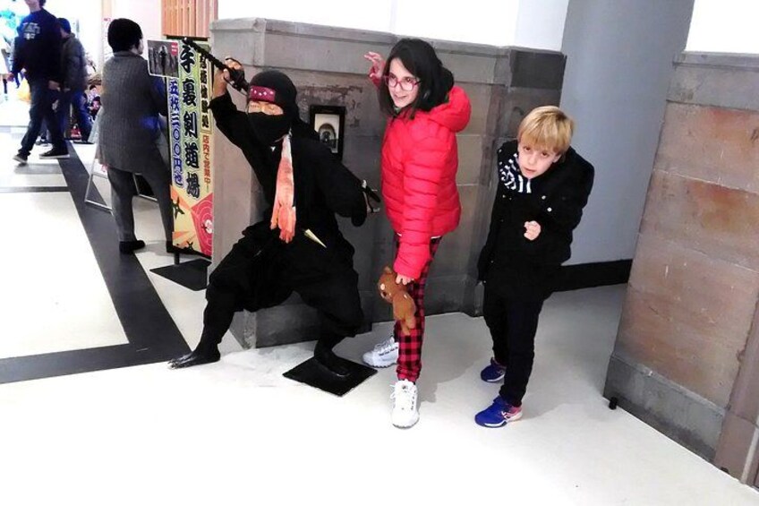 Una persona vestida de ninja, un niño con una chaqueta roja y otro niño con ropa negra. 4