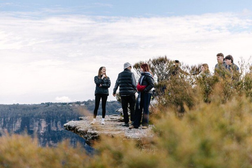 A group of people standing on a rocky outcrop overlooking a valley. 2