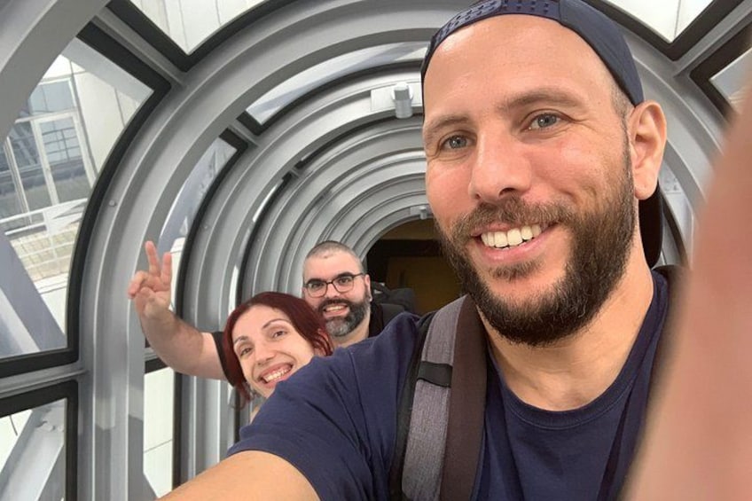 A person taking a selfie with a modern architectural structure in the background. 4