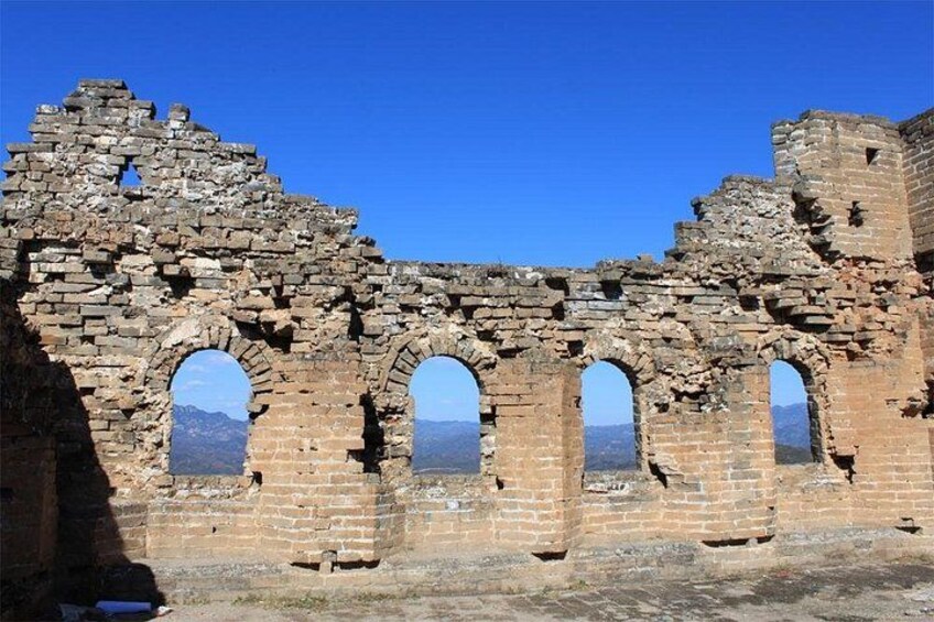 Vestiges d’un ancien bâtiment en briques, avec des fenêtres en arc et un mur partiellement intact. 5