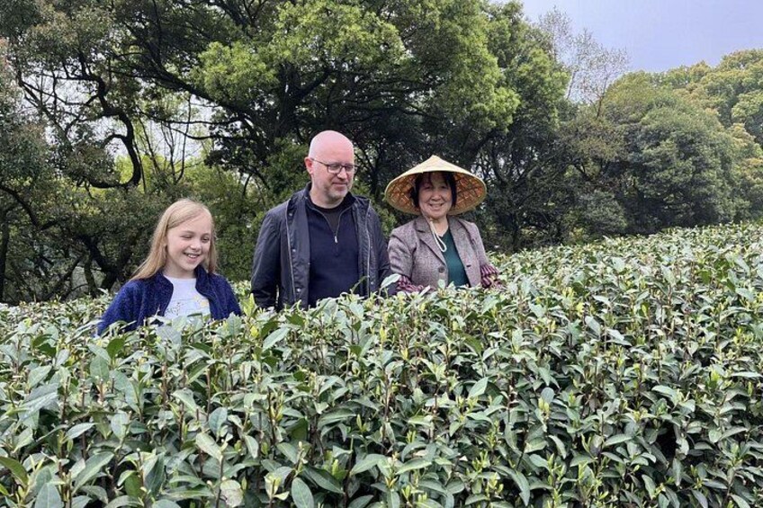 Three people standing in a tea plantation. 5