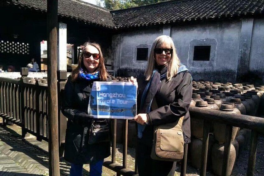 Two people holding a sign that reads 'Hangzhou Private Tour.' 2