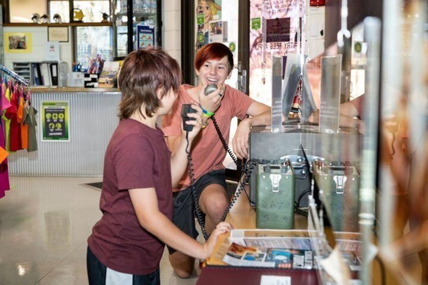 Una persona hablando por teléfono dentro de una tienda con varios artículos en las estanterías. 4