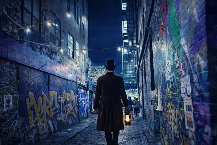 A person walking down a graffiti-covered alleyway at night. 5