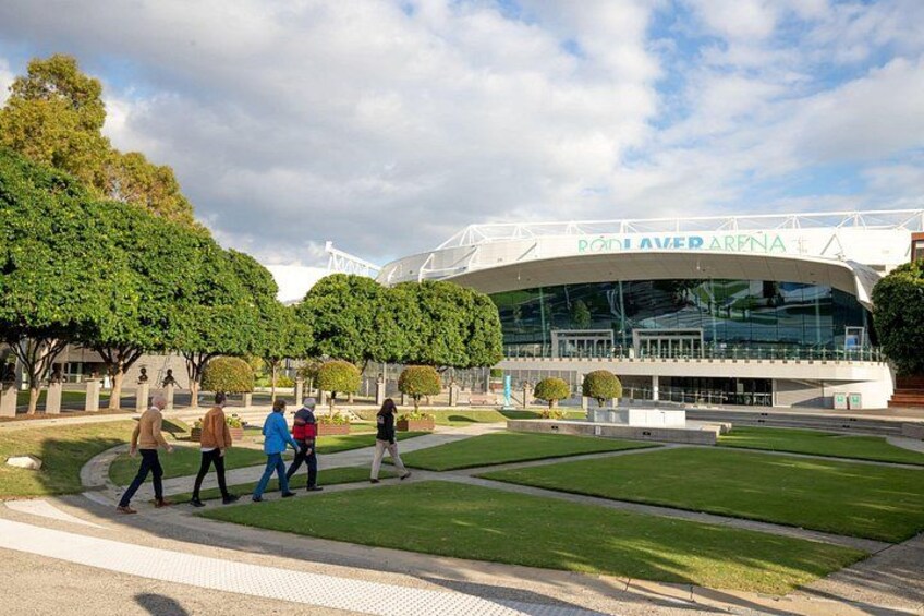 A stadium with a modern design, surrounded by well-maintained grass and trees. 4