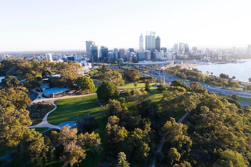 A city skyline with modern buildings, a park with green spaces, and a body of water. 4