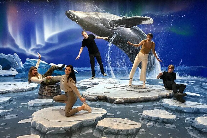 A group of people on ice floes with a whale and aurora in the background. 4