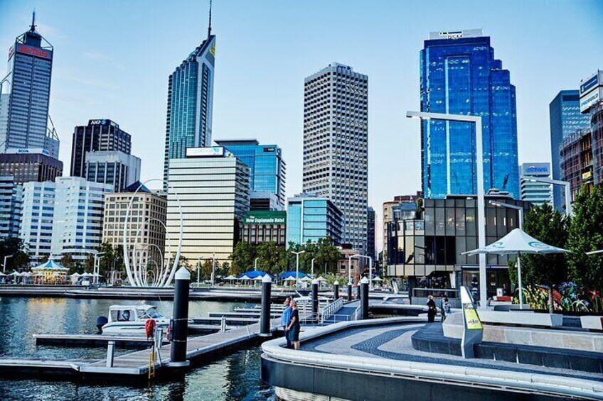 A cityscape with modern skyscrapers, a marina, and a waterfront promenade. 2