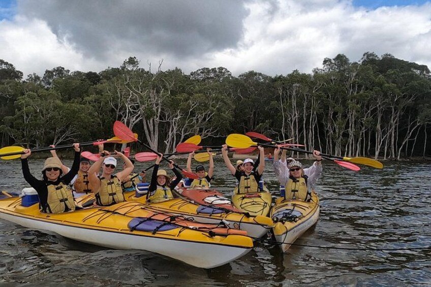 Un grupo de personas haciendo kayak en un río rodeado de árboles. 2