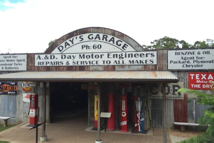 A vintage garage with signs for A&D Day Motor Engineers and Benzine & Oil. 2