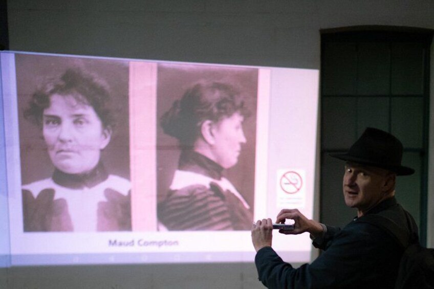 A person holding a camera, projecting images of a woman onto a screen. 3