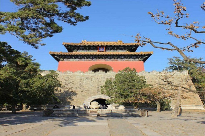 A traditional Chinese gate with a red and yellow roof, surrounded by trees and a stone pathway. 3
