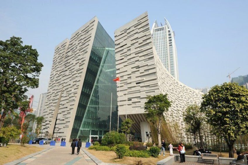 A modern building with a unique angular design, surrounded by trees and a clear sky. 5