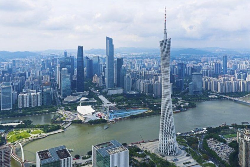 A cityscape with a prominent tower, a river, and surrounding high-rise buildings. 3