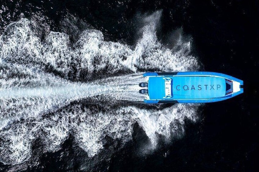 A blue speedboat with 'COASTXP' written on the side, moving through water creating a wake. 4