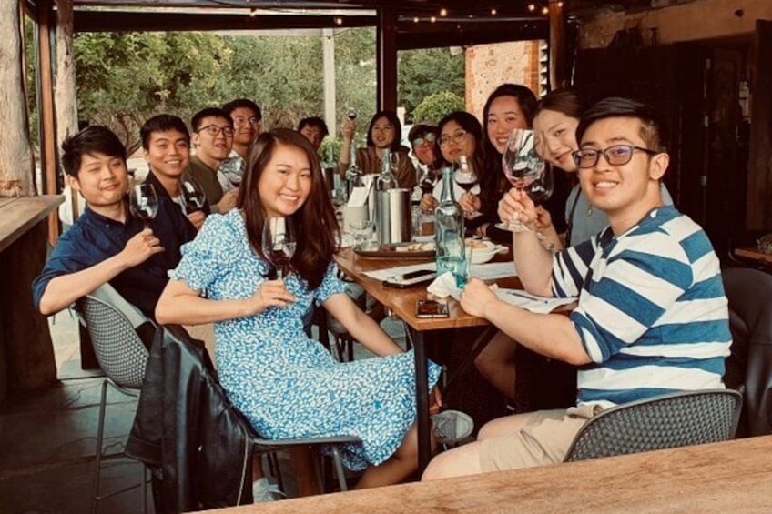 A group of people toasting with wine glasses at a restaurant. 4