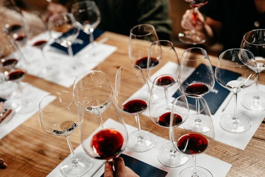Copas de vino sobre una mesa, algunas llenas de vino tinto. 2