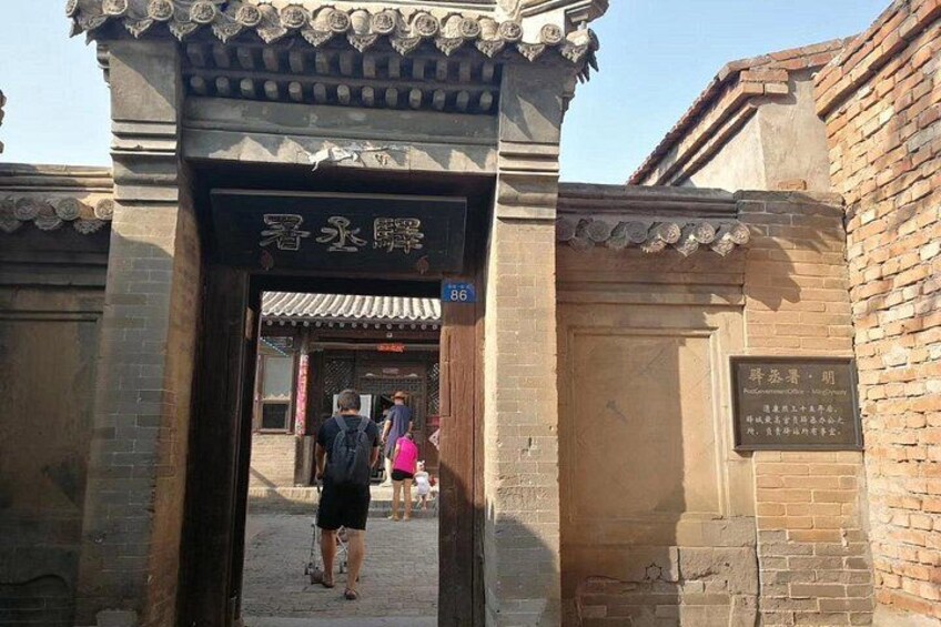 A traditional Chinese gate with a sign, leading to a courtyard. 4