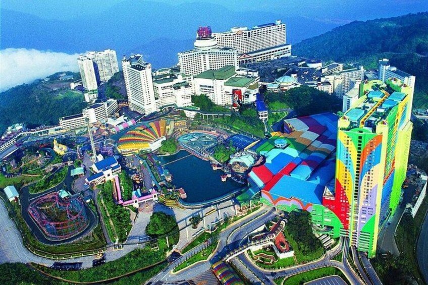 Une vue urbaine avec un bâtiment aux couleurs vives, une étendue d’eau importante et un paysage montagneux en arrière-plan. 2