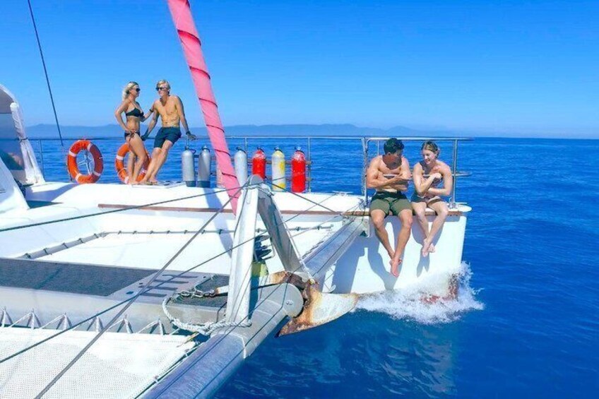Un velero con gente en cubierta, un flotador y un mar azul y despejado. 2
