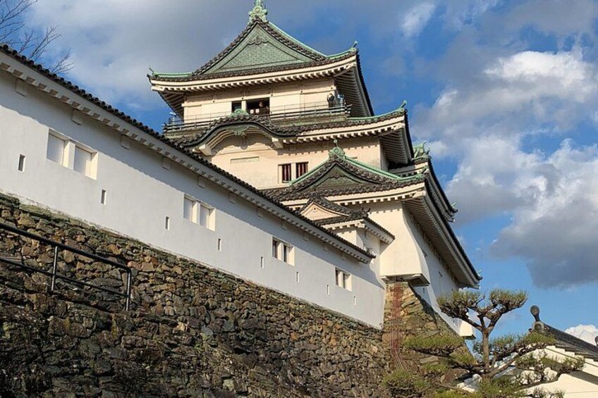 Un château japonais traditionnel, doté de plusieurs niveaux, de murs en pierre et surplombant un ciel dégagé. 2