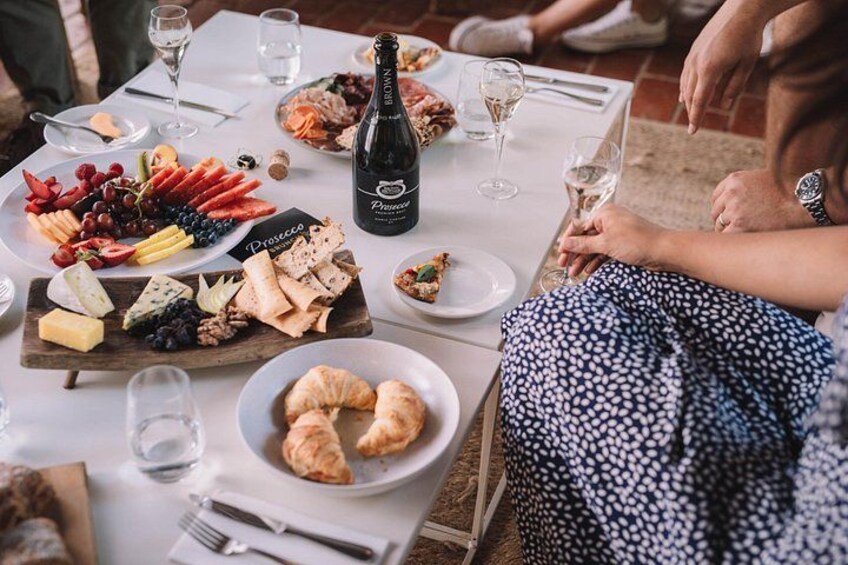 Une table dressée pour un repas, avec une variété de fromages, de fruits et de pâtisseries. 3