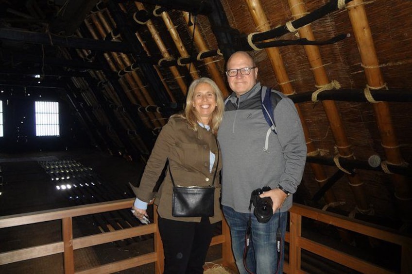 Two people standing in a wooden structure with a sloped roof. 2