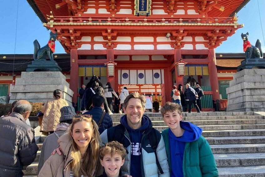 Un temple japonais traditionnel, avec une porte torii rouge, des statues de pierre et des visiteurs. 3