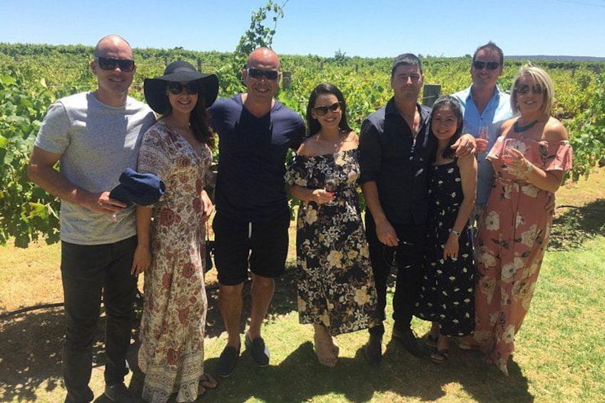 Un groupe de personnes se tient dans un vignoble. 2