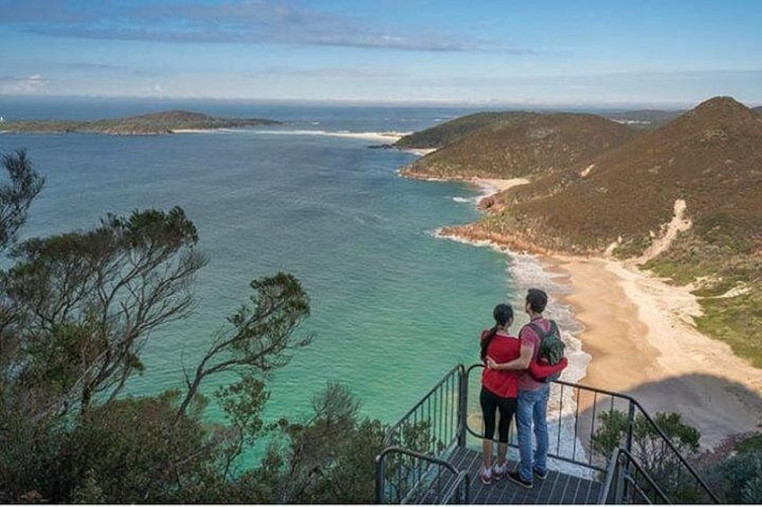A coastal landscape with a beach, ocean, and hills. 2