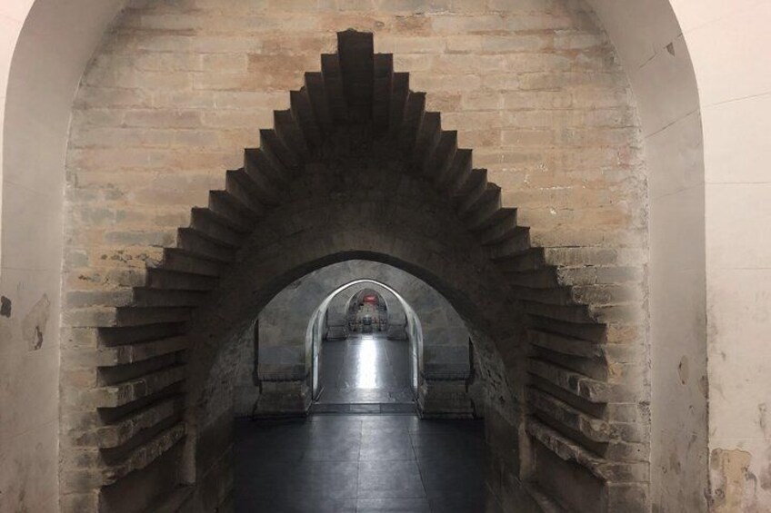 A stone staircase leading up to a metal door with a circular window. 5