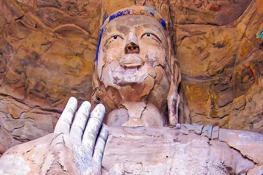 Een sculptuur van een menselijke figuur met een structuurrijk oppervlak, mogelijk van klei of gips, voor een achtergrond die lijkt op een rotsachtige muur. 1