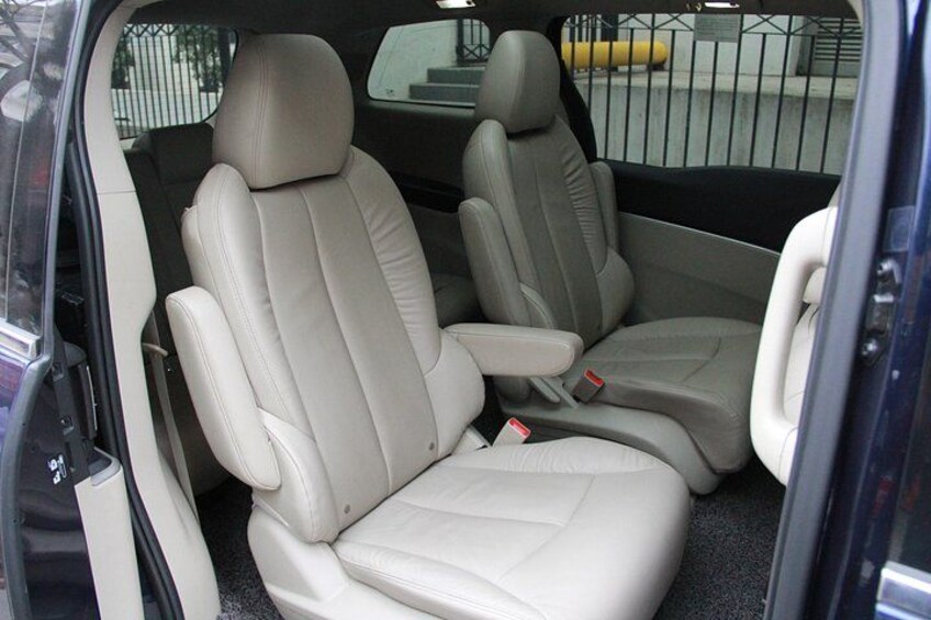 A car's interior with beige leather seats and a center console. 1