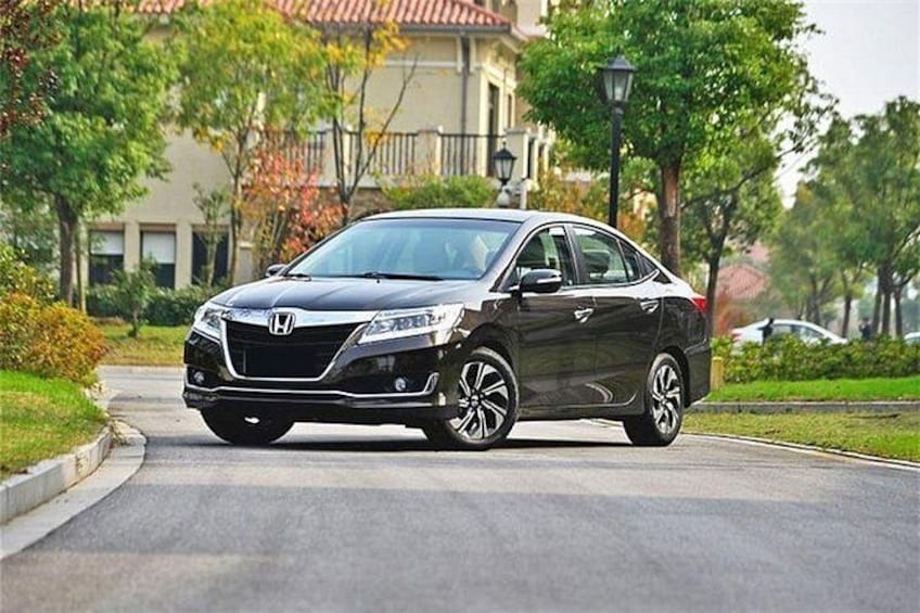 A black Honda sedan parked on a residential street with houses and trees in the background. 3