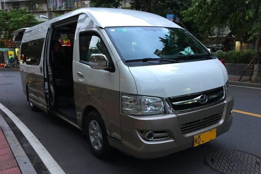 A silver van with its door open, parked on a city street. 4