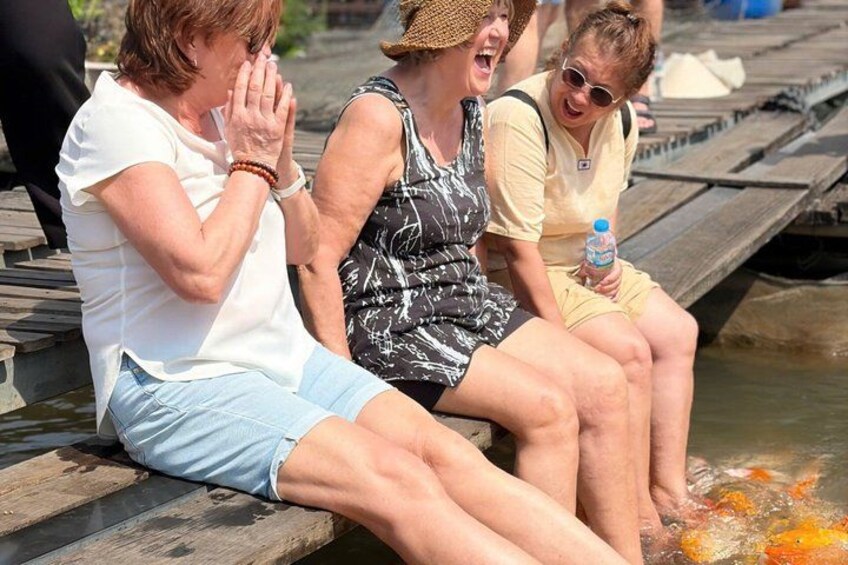 People sitting on a wooden dock by a body of water. 4
