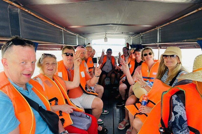 People wearing orange life jackets on a boat. 2