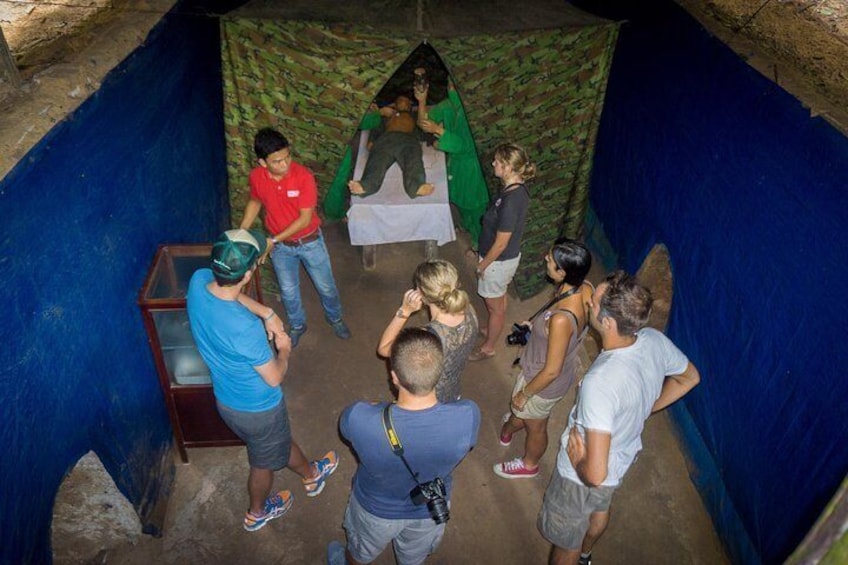 A group of people observing a mannequin in a cave-like setting. 2