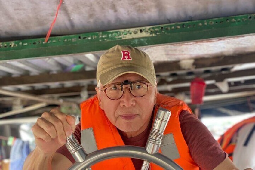 A person in an orange safety vest operating a valve. 1