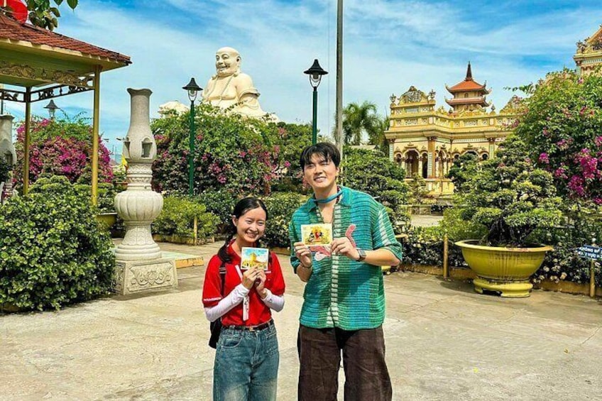 Twee personen met boeken voor een groot standbeeld en een tempel. 5