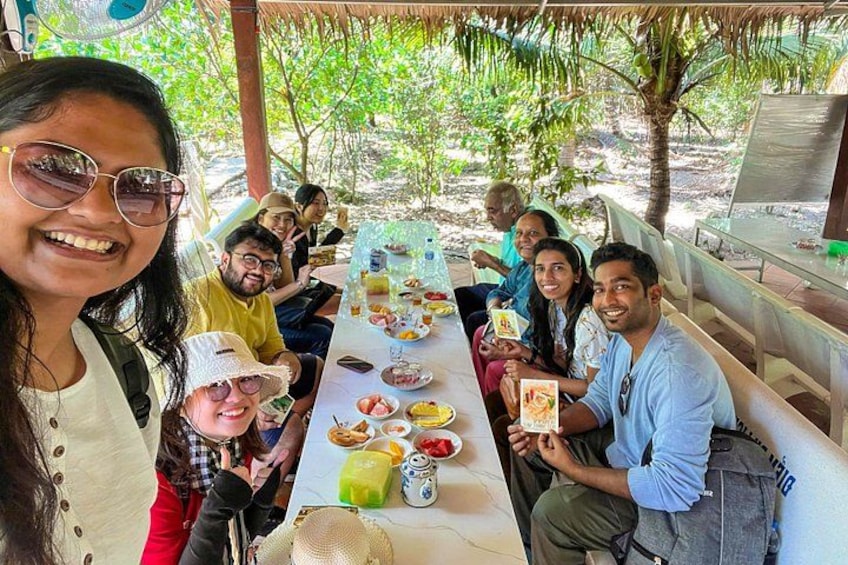A group of people dining outdoors at a table with various dishes. 5